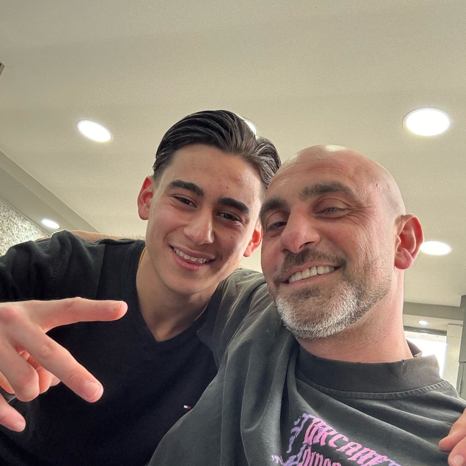 Two people smiling together inside Star Barbershop
